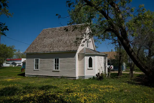 Small white church among dandelions